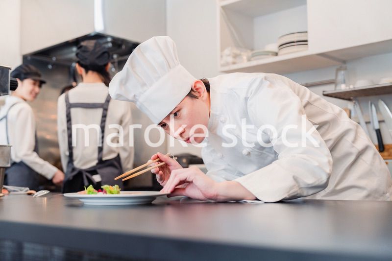 厨房で盛り付けをする男性シェフ