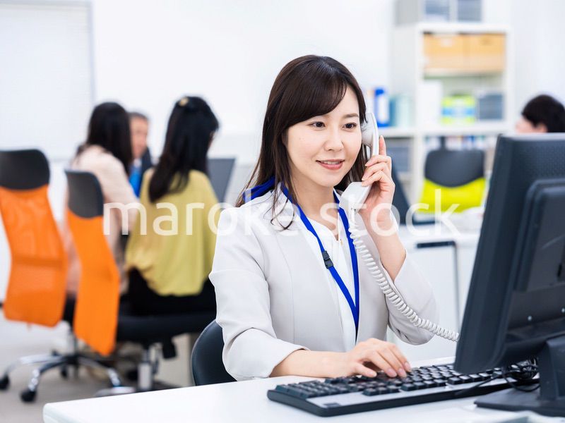 オフィスで固定電話を使う女性