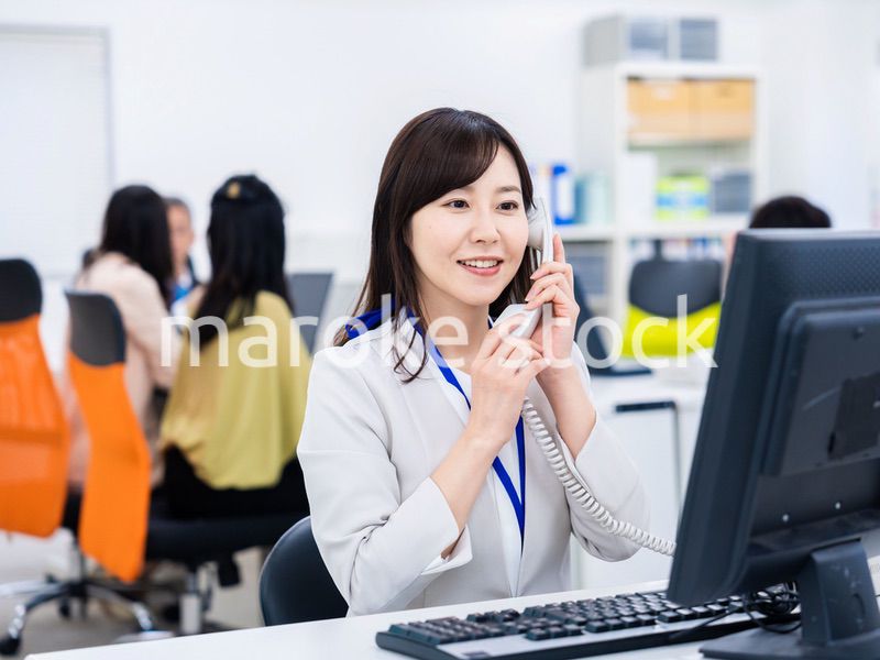 オフィスで固定電話を使う女性