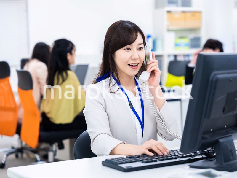 オフィスで固定電話を使う女性