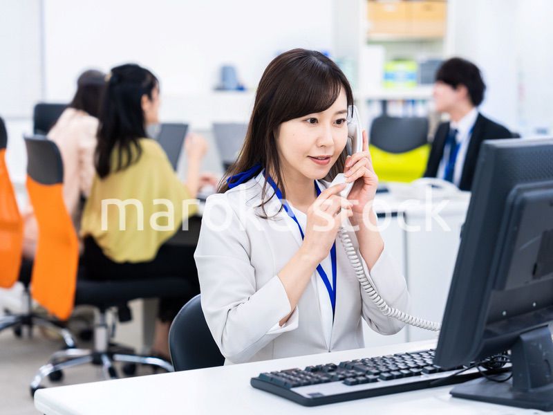 オフィスで固定電話を使う女性