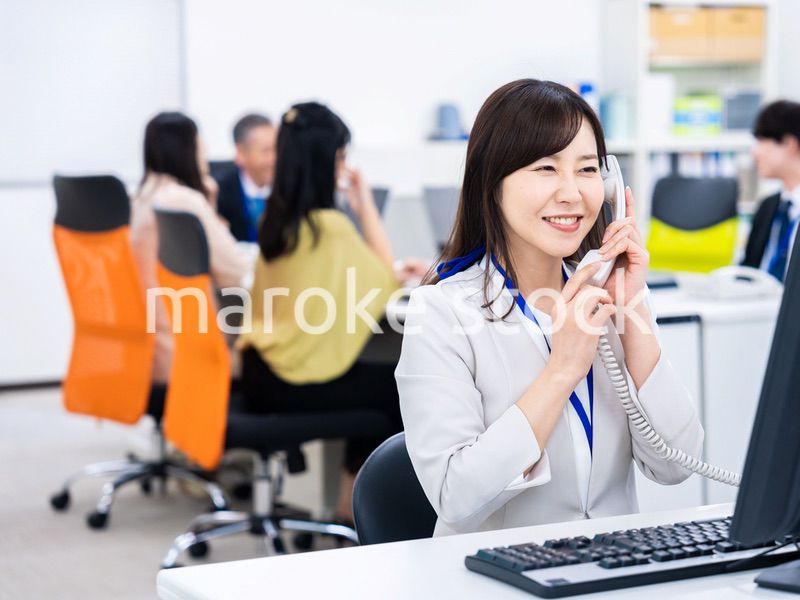 オフィスで固定電話を使う女性