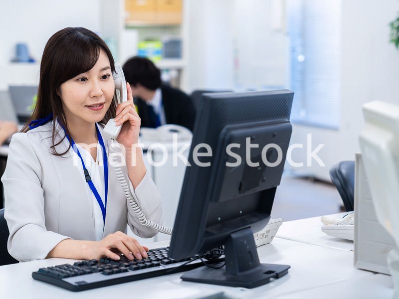 オフィスで固定電話を使う女性
