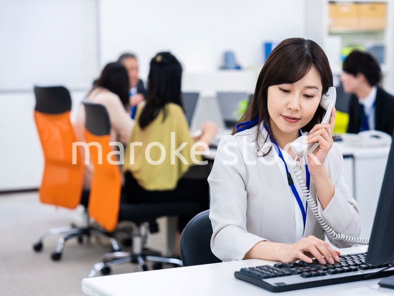 オフィスで固定電話を使う女性