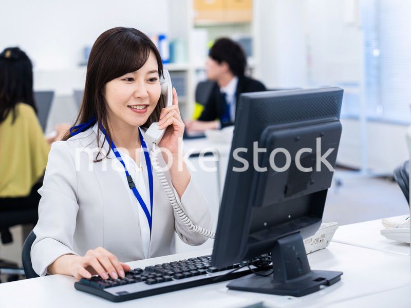 オフィスで固定電話を使う女性