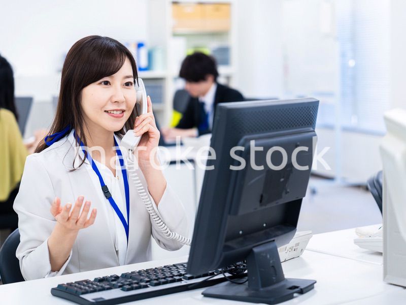 オフィスで固定電話を使う女性