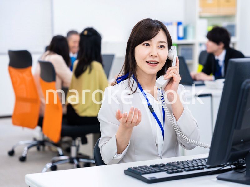 オフィスで固定電話を使う女性