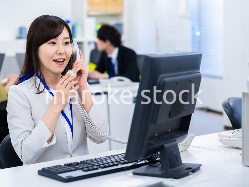 オフィスで固定電話を使う女性