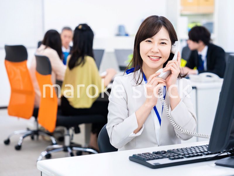 オフィスで固定電話を使う女性