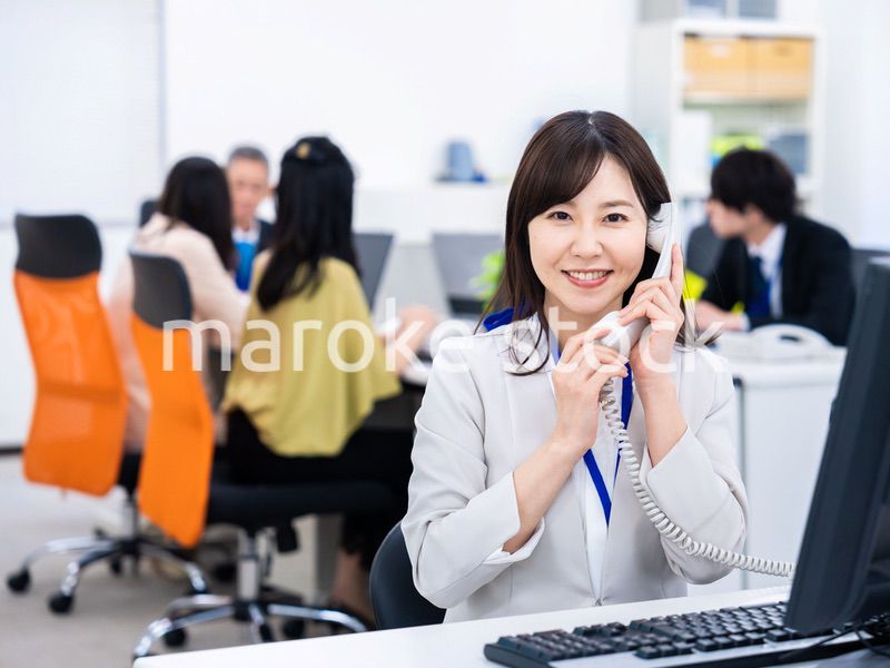 オフィスで固定電話を使う女性