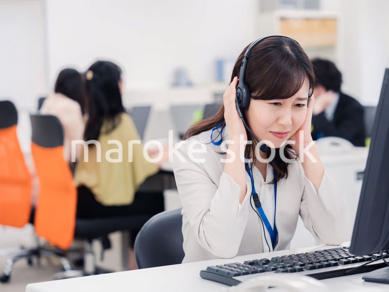 電話対応で疲労するお客様センターの女性