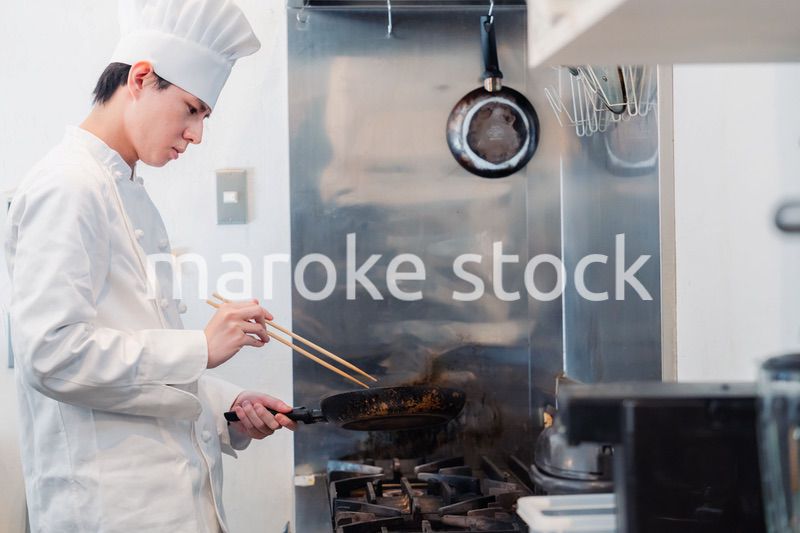 フライパンで調理をする男性シェフ