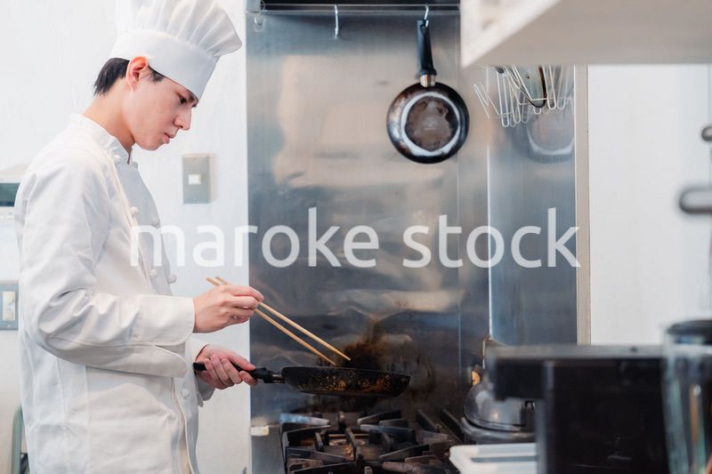 フライパンで調理をする男性シェフ