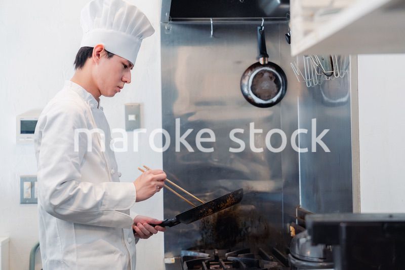 フライパンで調理をする男性シェフ