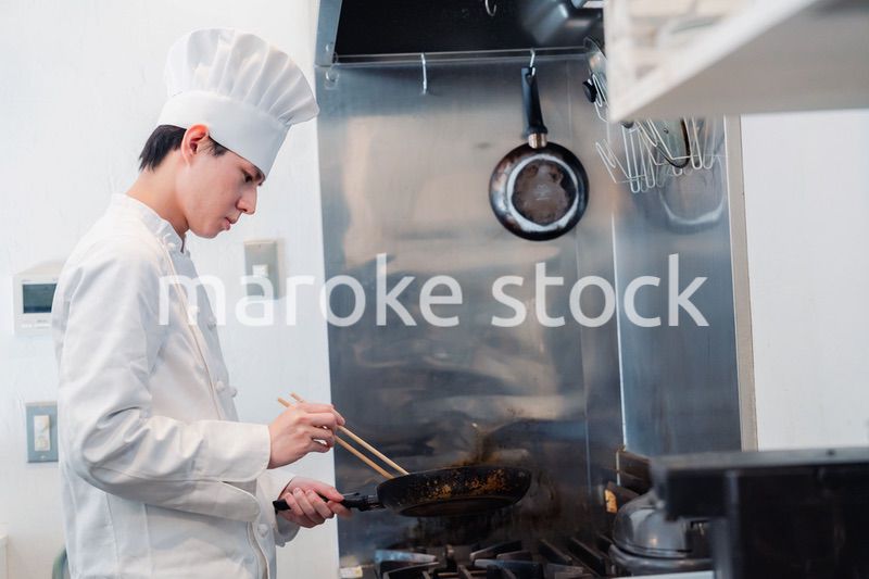 フライパンで調理をする男性シェフ