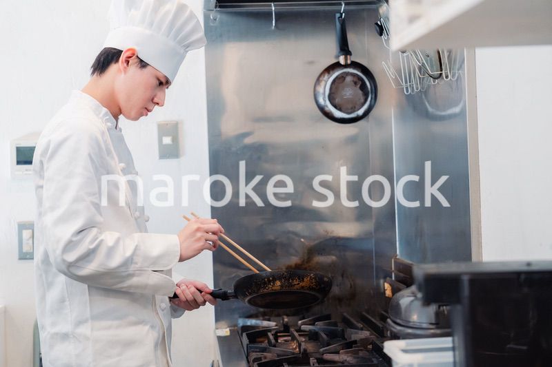 フライパンで調理をする男性シェフ