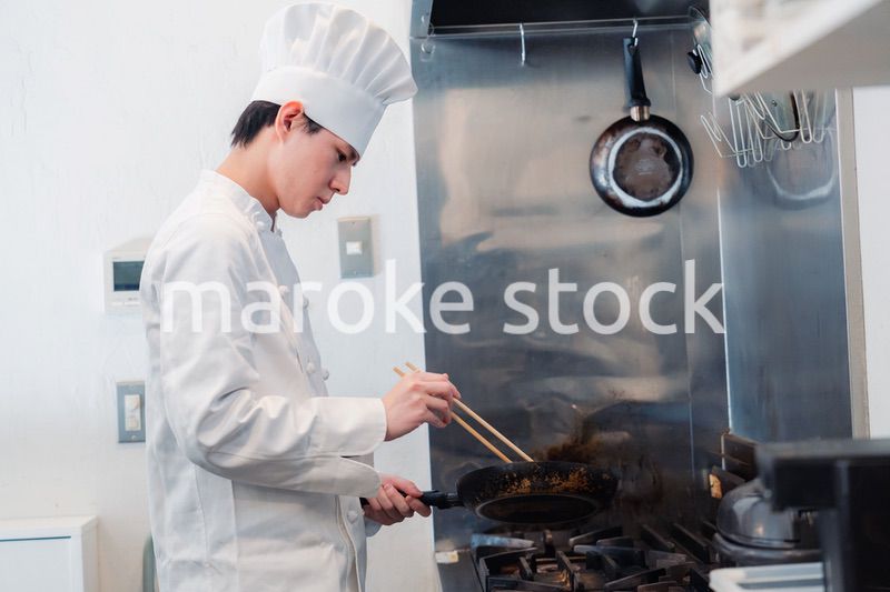 フライパンで調理をする男性シェフ
