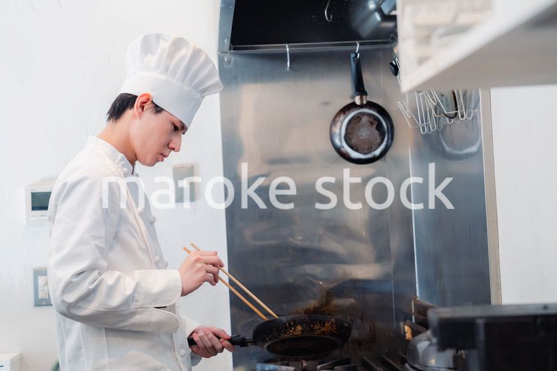 フライパンで調理をする男性シェフ