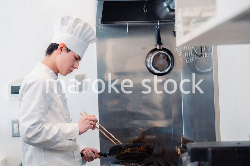 フライパンで調理をする男性シェフ