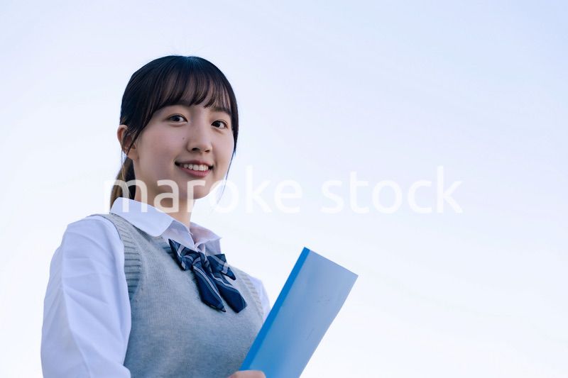 外で遠くを見る制服を着た女子高生