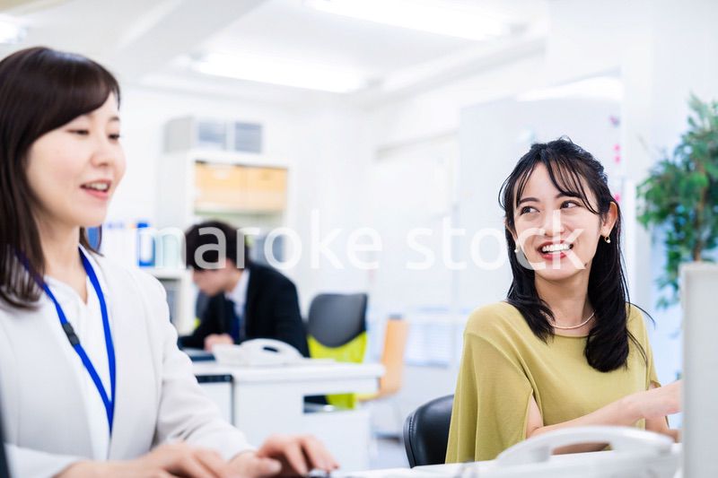楽しく話をしながらデスクワークをする女性