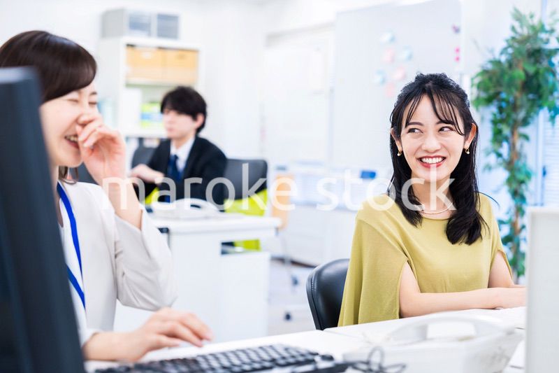 楽しく話をしながらデスクワークをする女性
