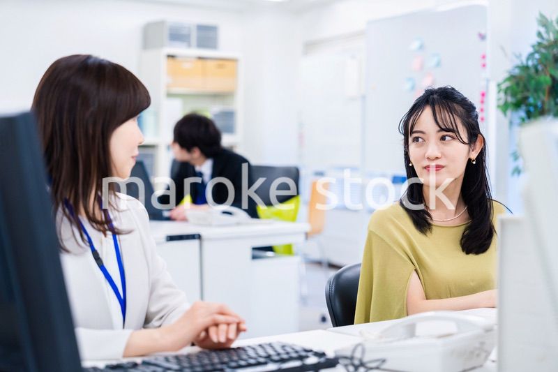 楽しく話をしながらデスクワークをする女性