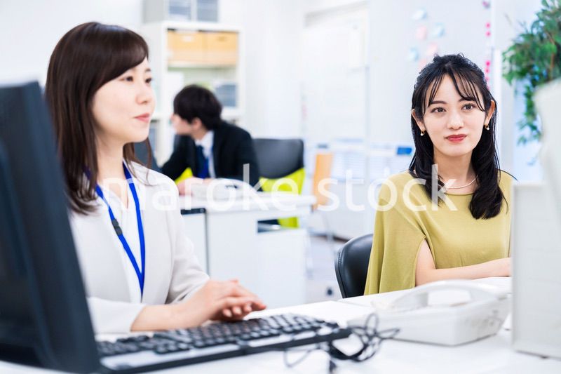 楽しく話をしながらデスクワークをする女性