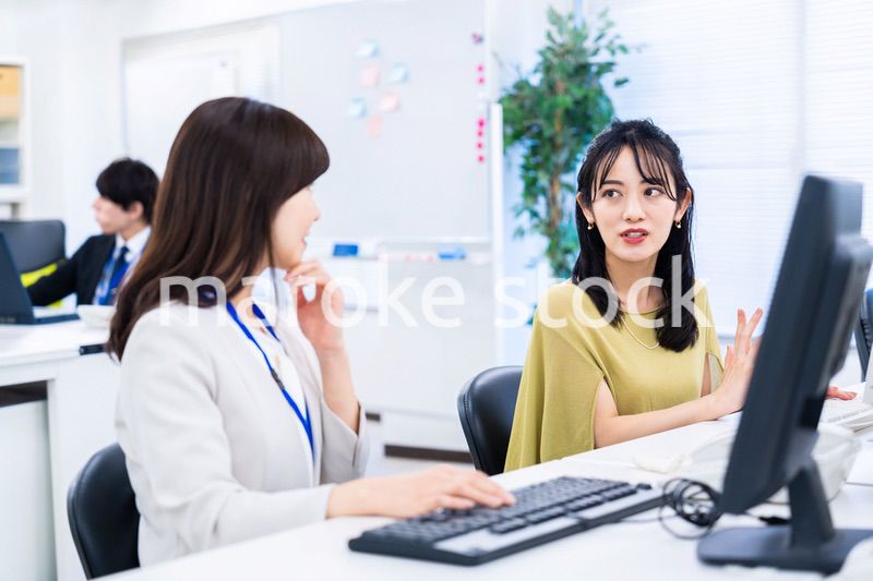 楽しく話をしながらデスクワークをする女性