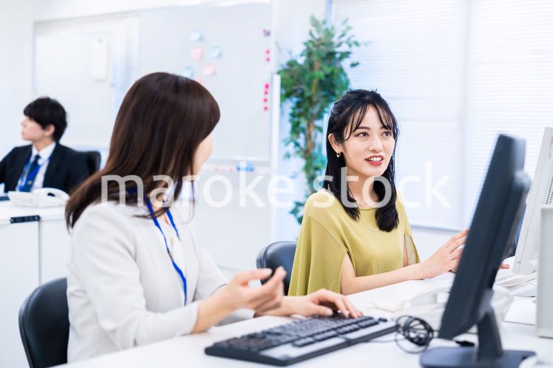 楽しく話をしながらデスクワークをする女性