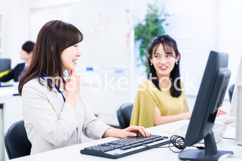 楽しく話をしながらデスクワークをする女性