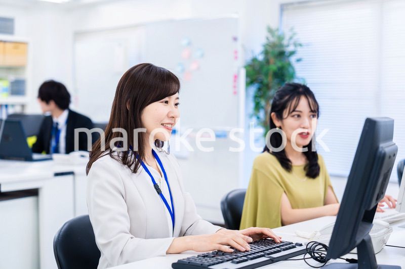 楽しく話をしながらデスクワークをする女性