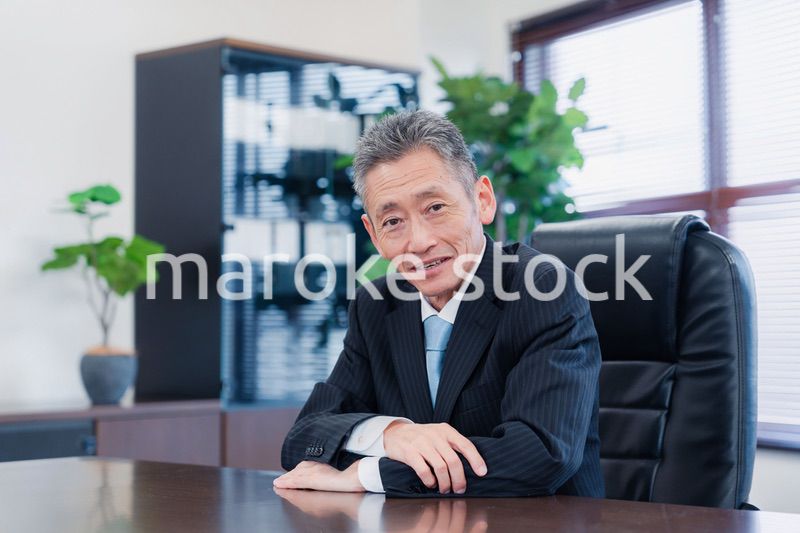 激務で眠い顔をする会社役員の男性