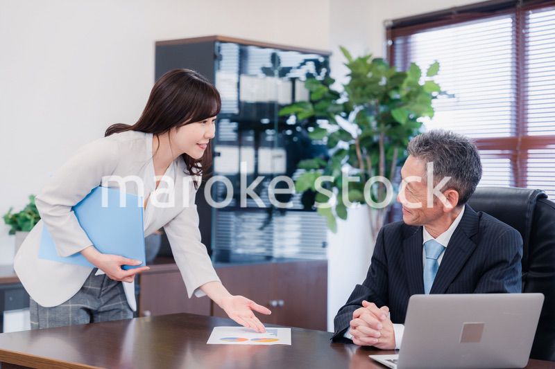 役員に報告をする秘書の女性