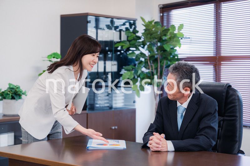 役員に報告をする秘書の女性