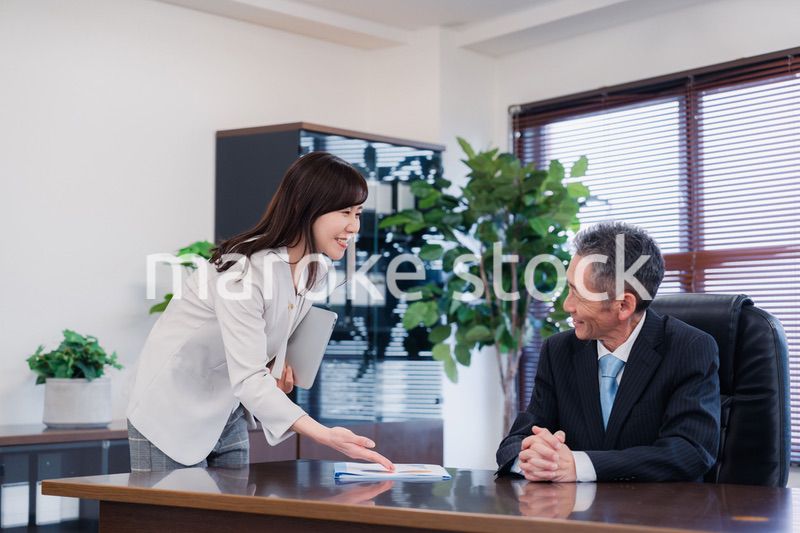 役員に報告をする秘書の女性