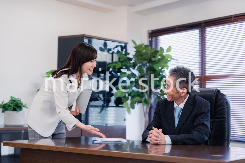 役員に報告をする秘書の女性