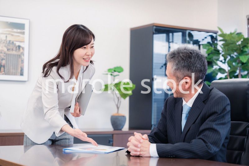 役員に報告をする秘書の女性