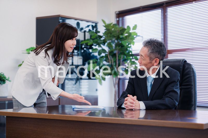 役員に報告をする秘書の女性