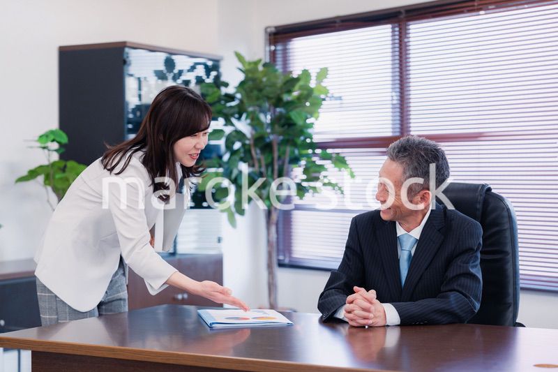 役員に報告をする秘書の女性