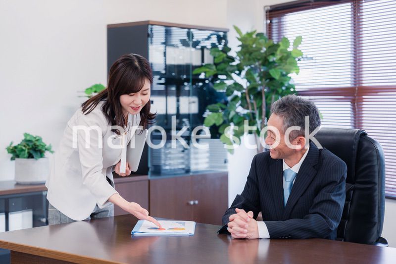 役員に報告をする秘書の女性