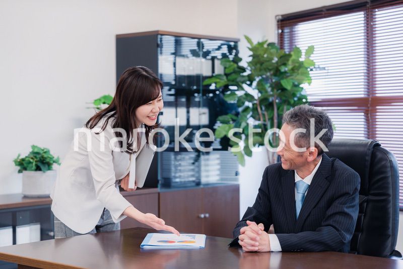 役員に報告をする秘書の女性