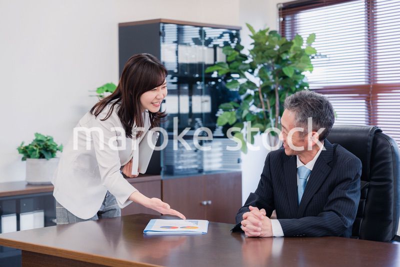 役員に報告をする秘書の女性