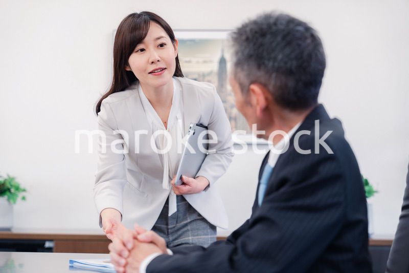 役員に報告をする秘書の女性