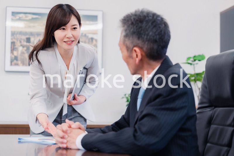 役員に報告をする秘書の女性
