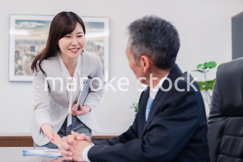 役員に報告をする秘書の女性