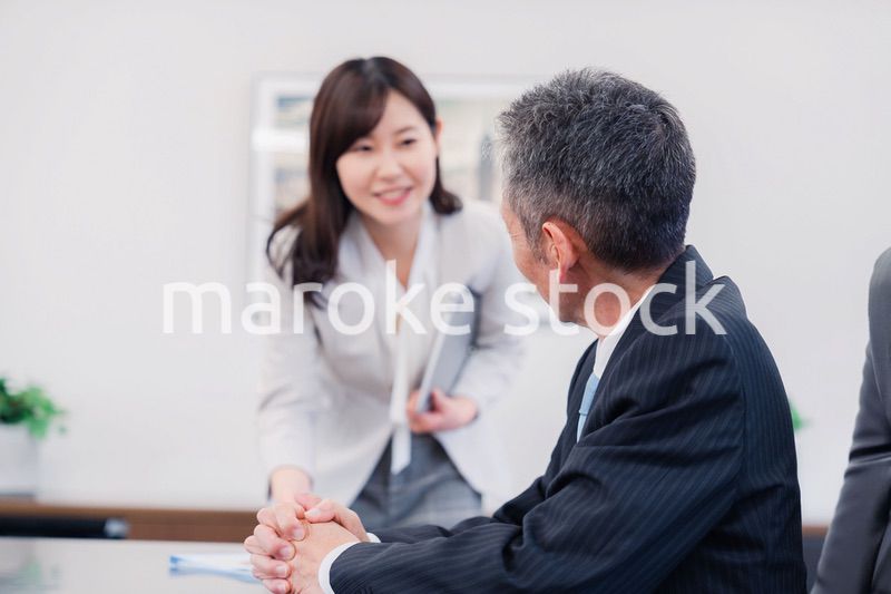 役員に報告をする秘書の女性