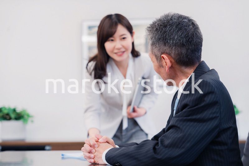 役員に報告をする秘書の女性