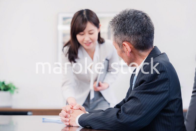 役員に報告をする秘書の女性