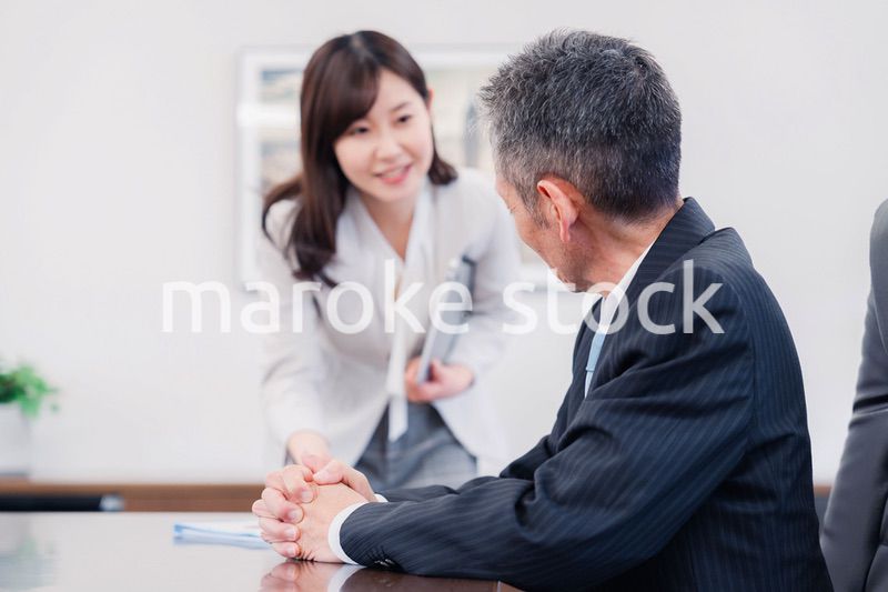 役員に報告をする秘書の女性